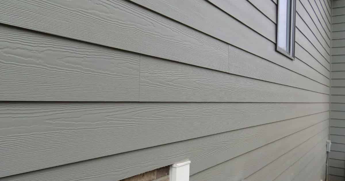 A close-up view of a house siding with horizontal, gray planks.